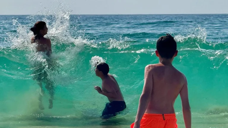 Menschen baden in den klaren Wellen des Atlantiks bei Peniche