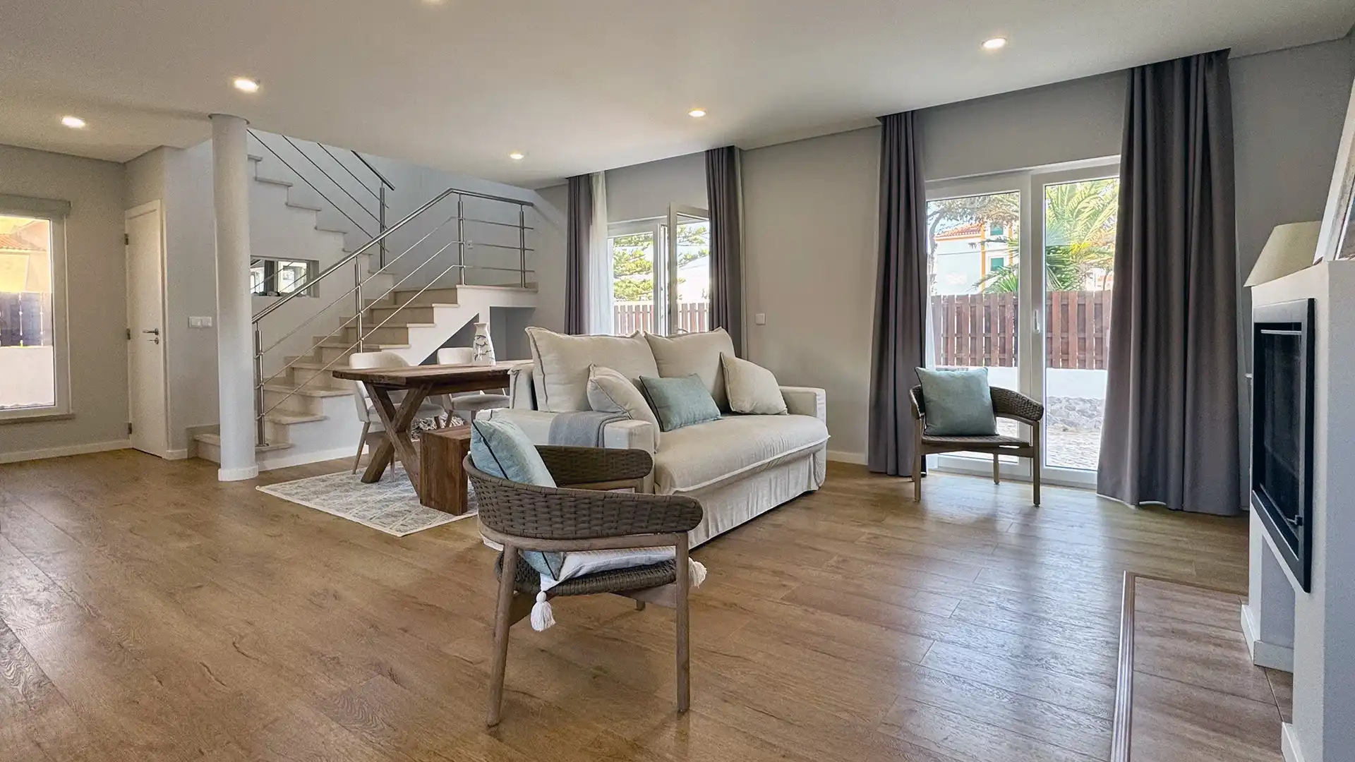 Heller Wohnbereich im Ferienhaus mit Sofa, Esstisch und Blick in den Garten