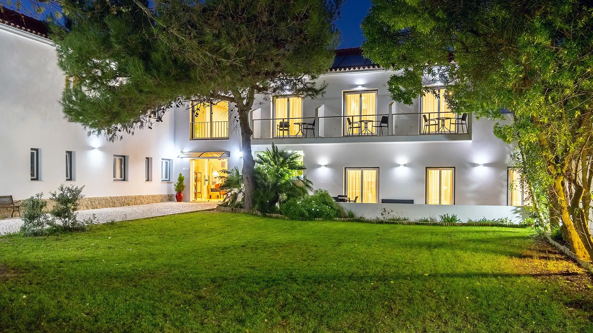 Außenansicht des Silver Seahorse Retreat bei Nacht mit beleuchtetem Garten