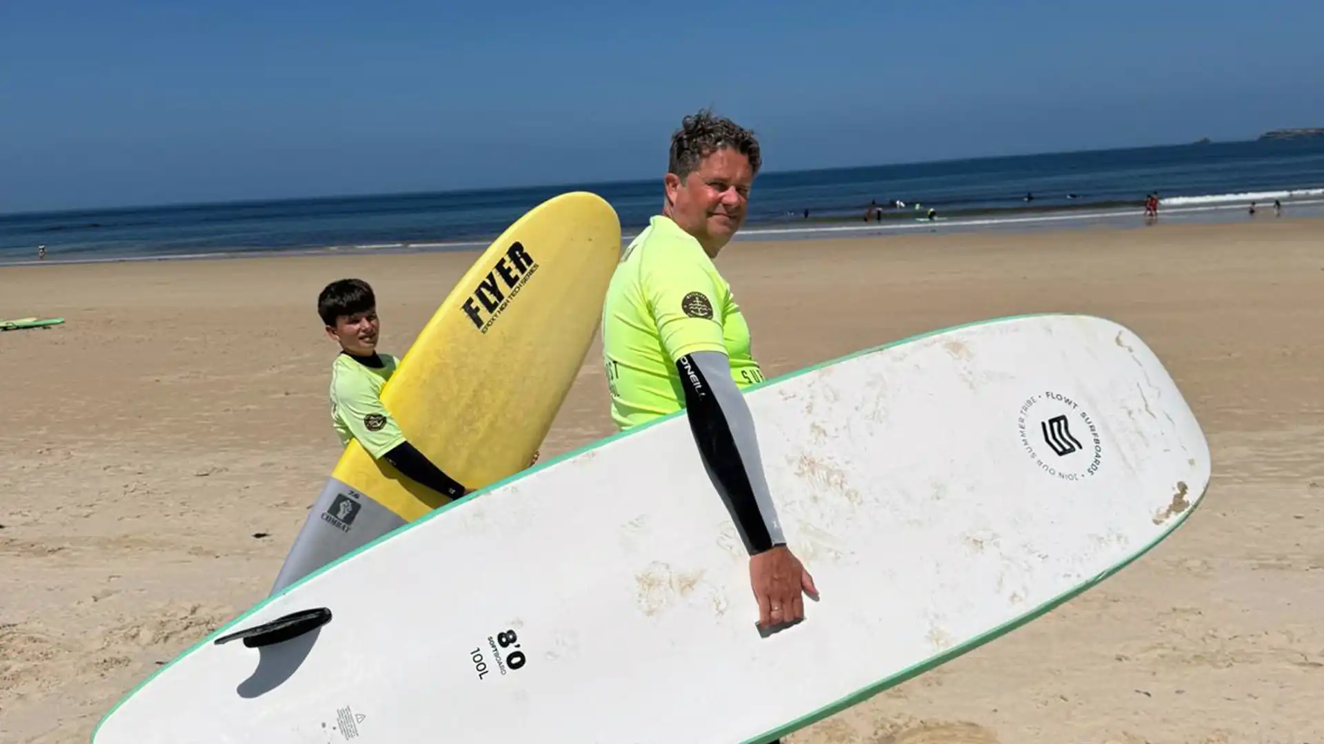 Surfkurs in Baleal mit Teilnehmern im Wasser und Trainer am Strand.