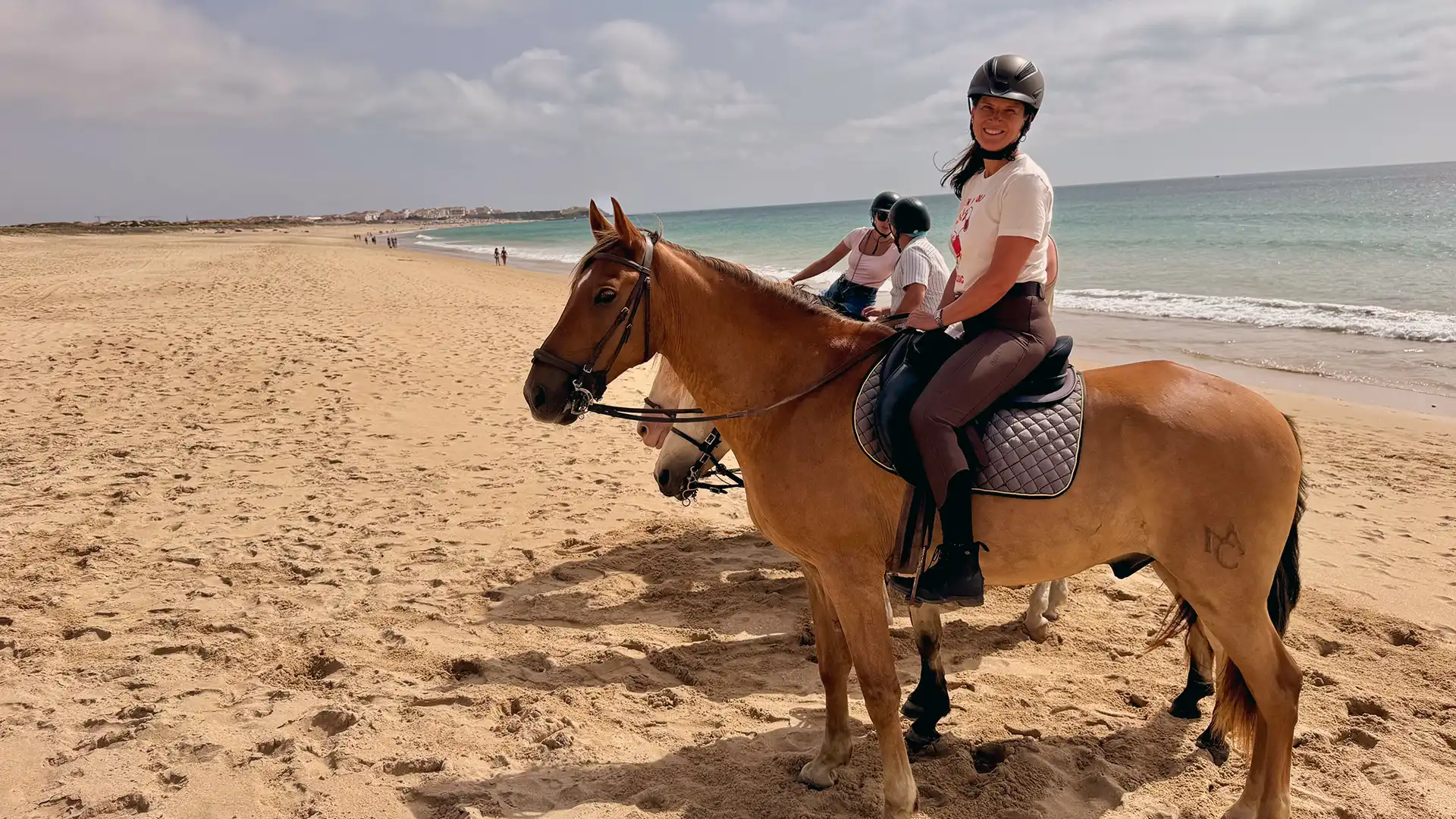 Reiterin auf einem Lusitano am endlosen Sandstrand bei Peniche.