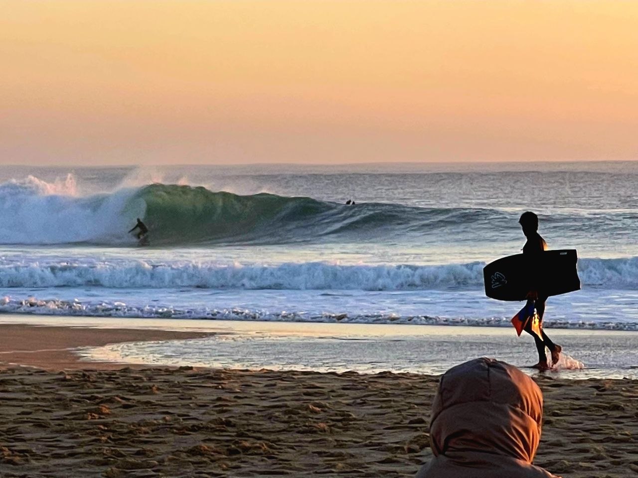 Ein Mann surft in einer Barrel bei der Wold Surf League am Strand Supertubos in Peniche.